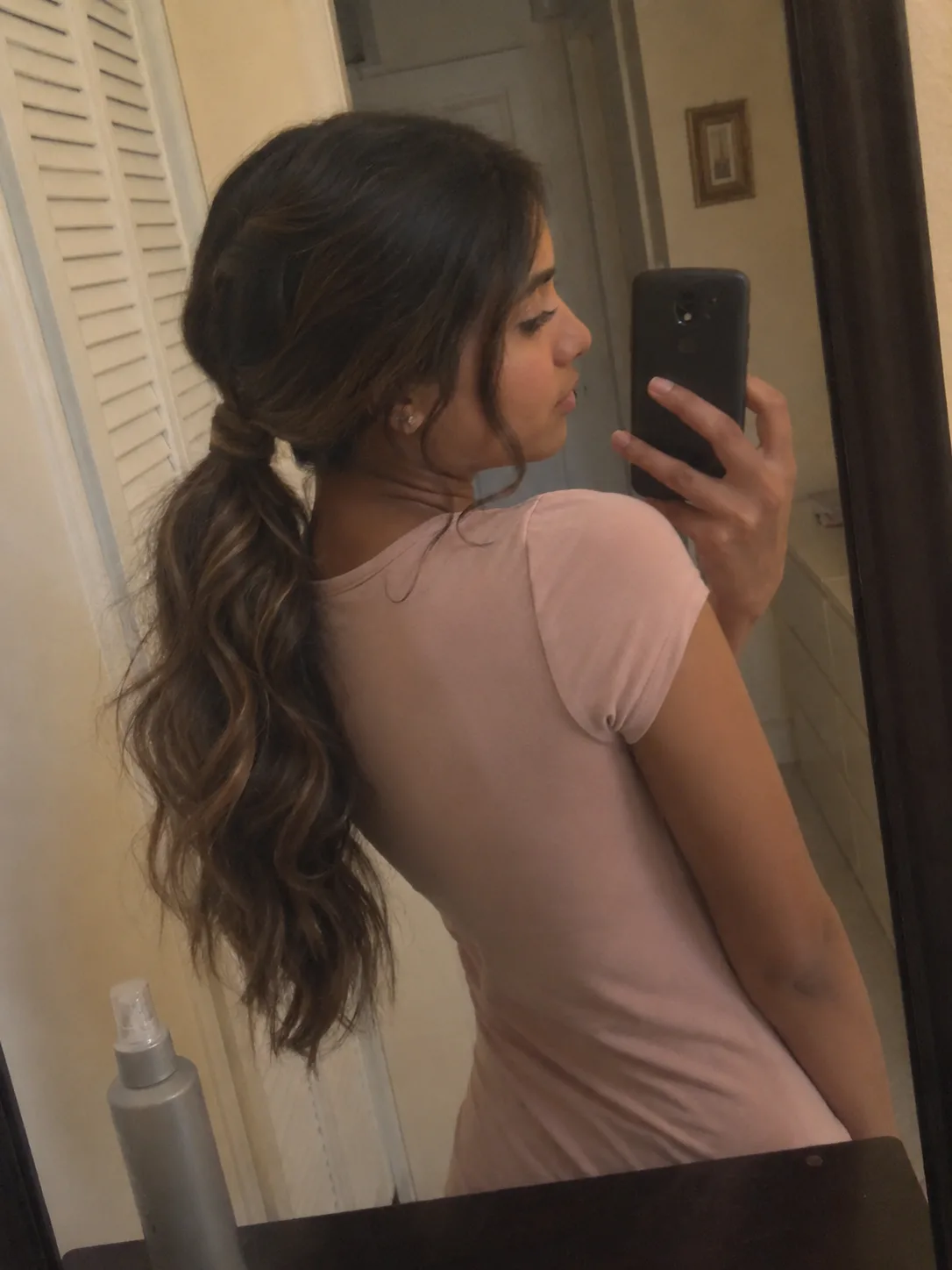 Thick hair bubble ponytail prom hairstyle with sleek crown and soft curled ends