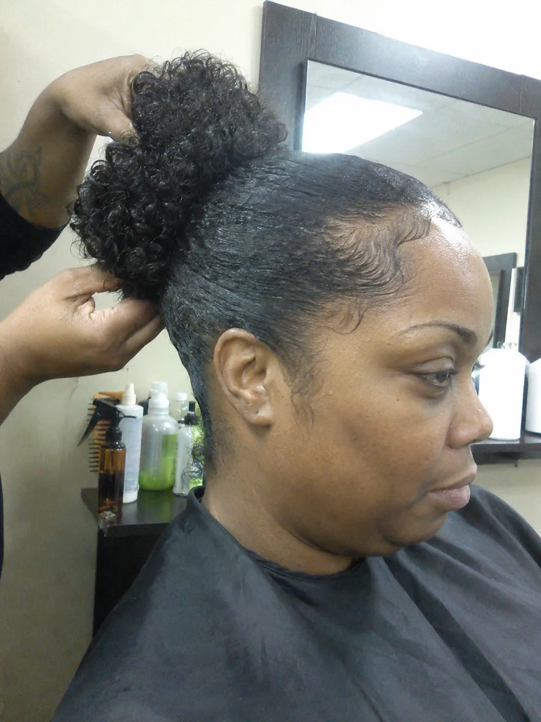 Two high, voluminous space buns styled with smooth edges, a fun and trendy curly look