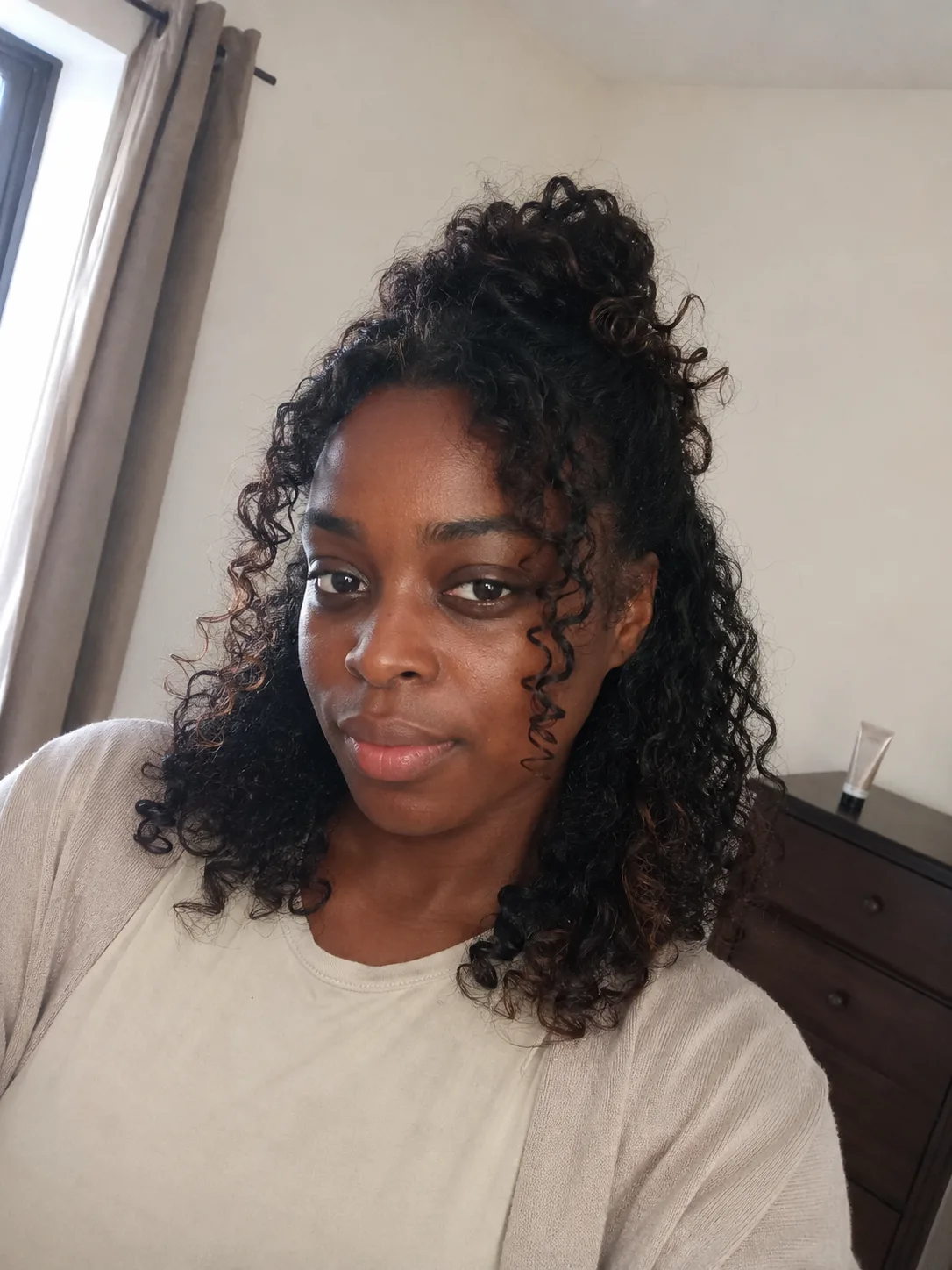 Voluminous natural curls wedding guest hairstyle with soft side volume