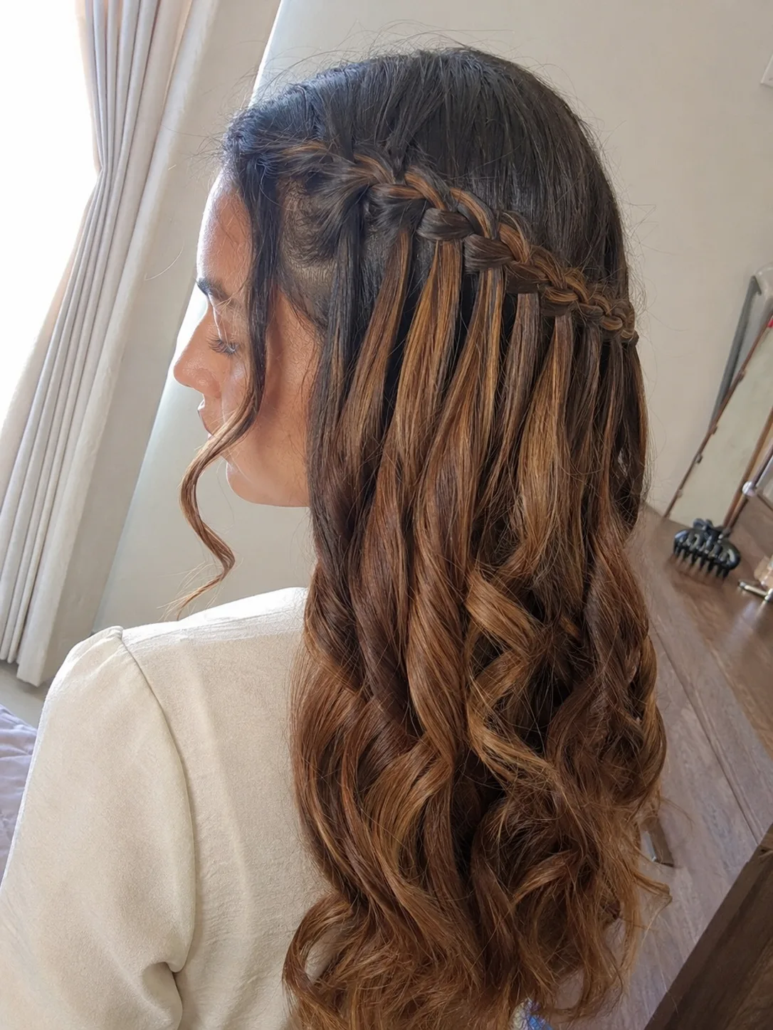 Waterfall braid prom hairstyle for long hair with loose curls