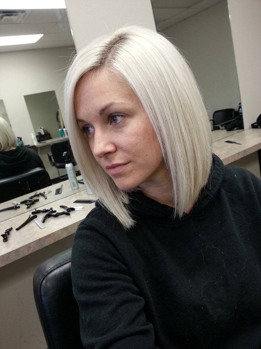 Woman with a short, wavy bob haircut featuring subtle pink highlights