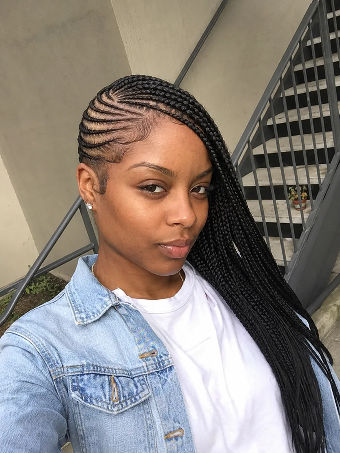 Woman with small black braids and face framing braided bangs showing neat summer braid root detail