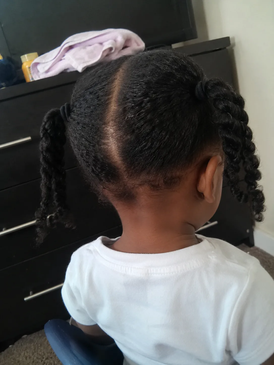 Working through toddler hair sections carefully to protect the stressed hair shaft