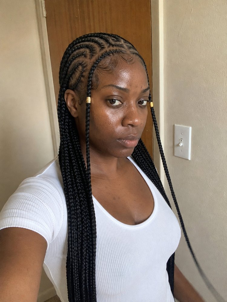 The hair is black, long, and styled in cornrows that extend down to a considerable length, past the shoulders or torso