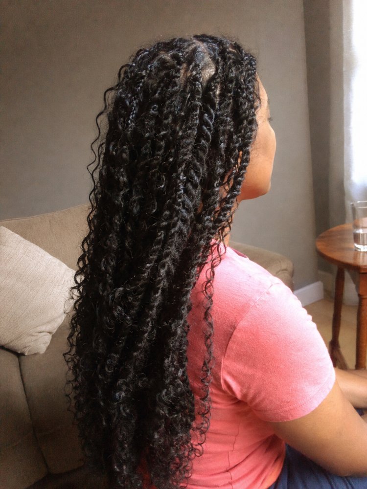 The hair is dark brown or black in color, with a curly texture and long length that extends down the back