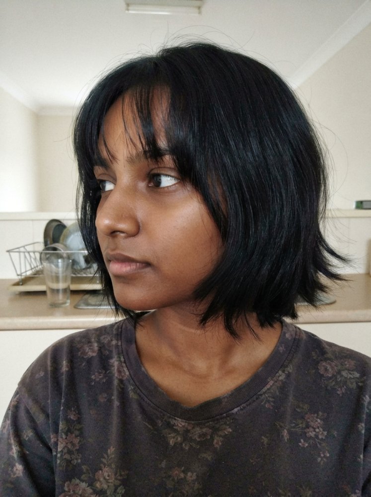 Short dark brown to black haircut with slight volume