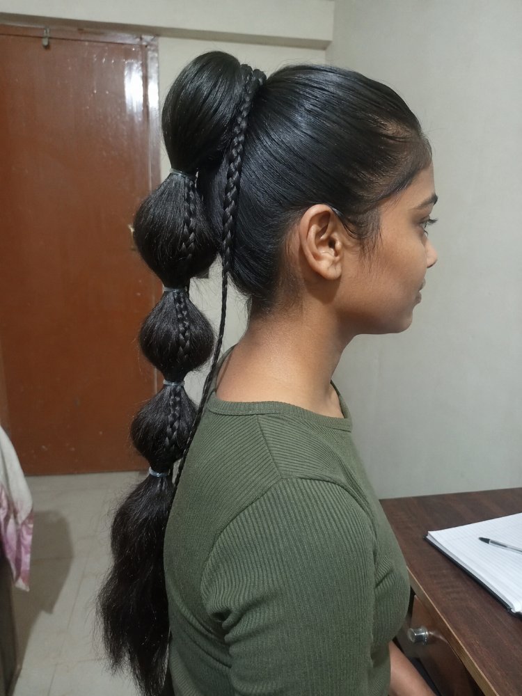 The hair is dark brown to black in color, smooth in texture, and is long, extending down to the lower back.