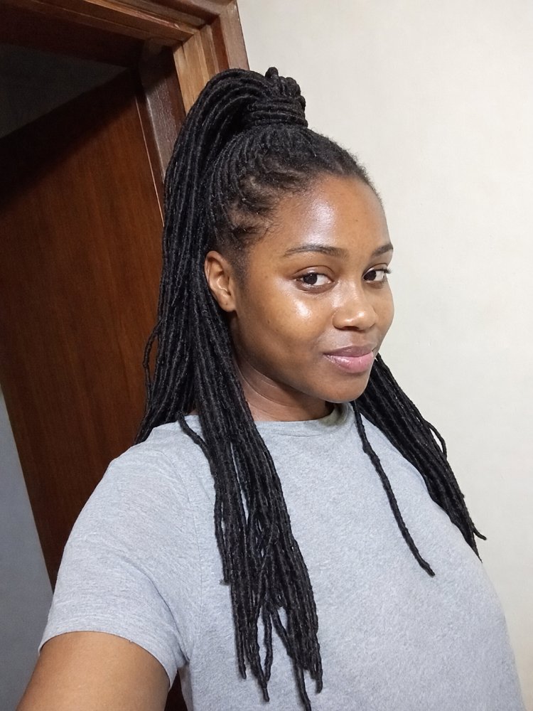 dark brown black color styled long The hair is dark brown-black in color, styled in long, thin, small-sized braids or locs that fall down to the mid-back area. The hair is pulled up into a high ponytail, with the locs neatly sectioned and secured, showcasing a smooth, sleek texture