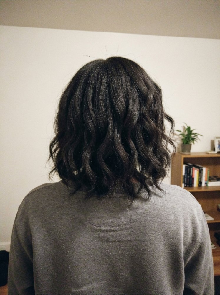 Dark brown shoulder-length wavy hair with soft layers.