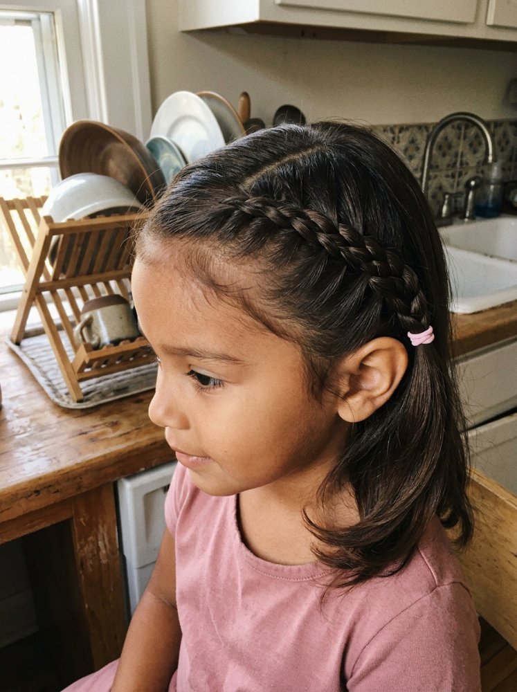 The hair is dark brown in color, with a medium length that falls just below the shoulders