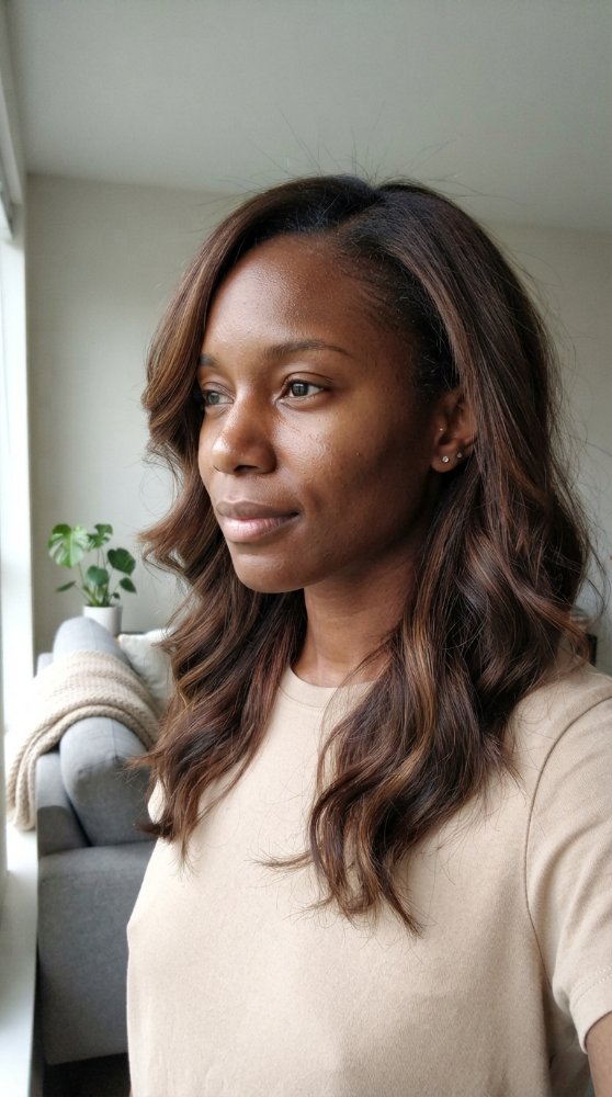 The hair is a dark brown color with subtle highlights of lighter brown, adding dimension and texture