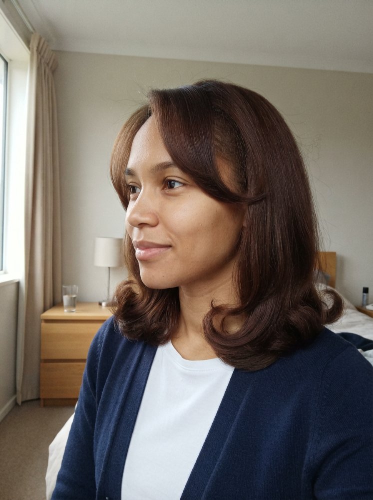 Dark brown layered hair with subtle face-framing pieces