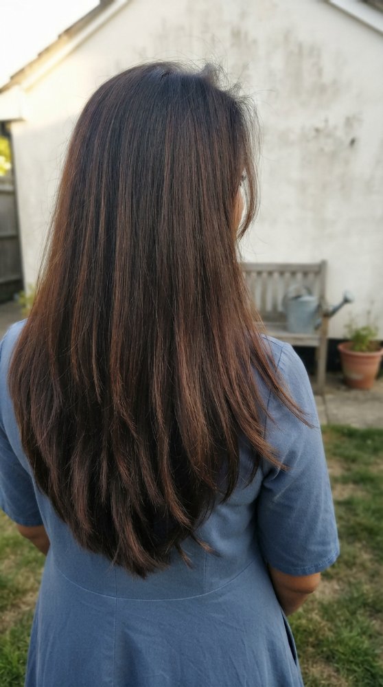 The hair is a dark brown color with subtle, lighter brown highlights throughout, giving it dimension and depth