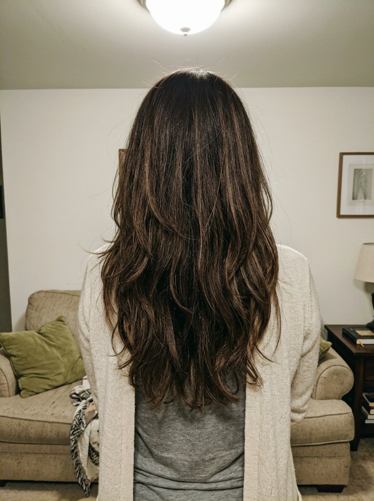 The hair is a dark brown color with subtle lighter brown highlights, giving it dimension and depth