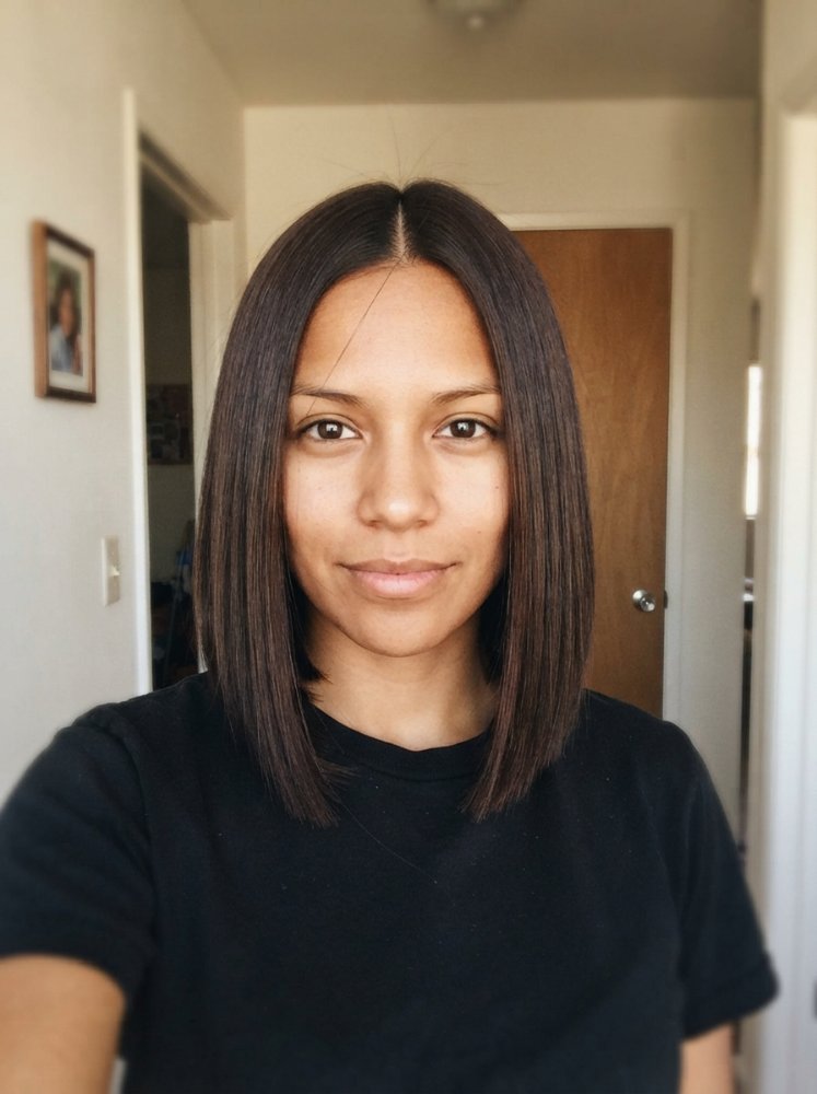 The hair is dark brown in color, with a uniform tone and a straight texture