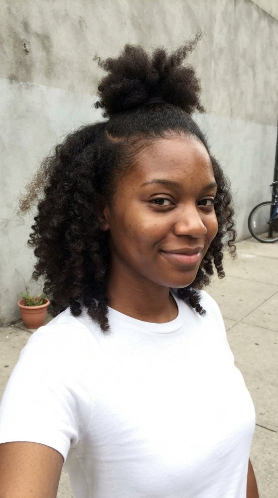 The hair is dark brown with a curly texture and medium length