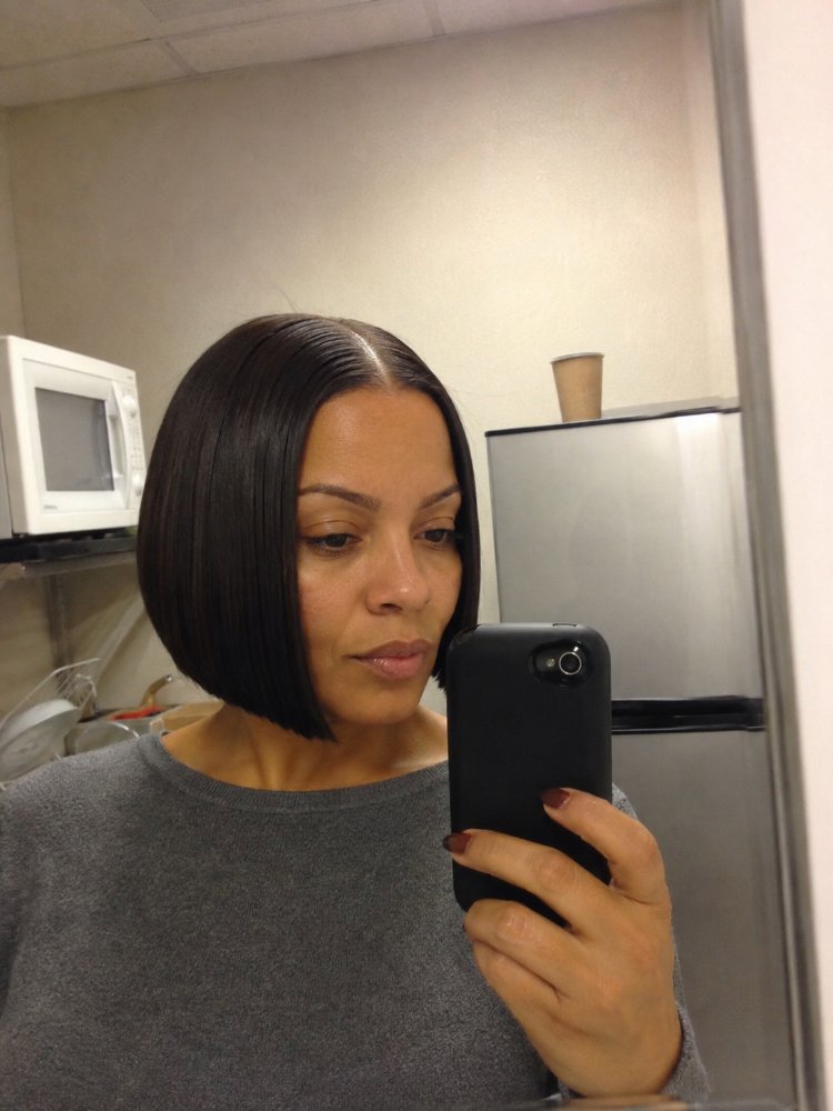 dark brown cut blunt bob The hair is dark brown, cut into a blunt bob that falls just below the chin