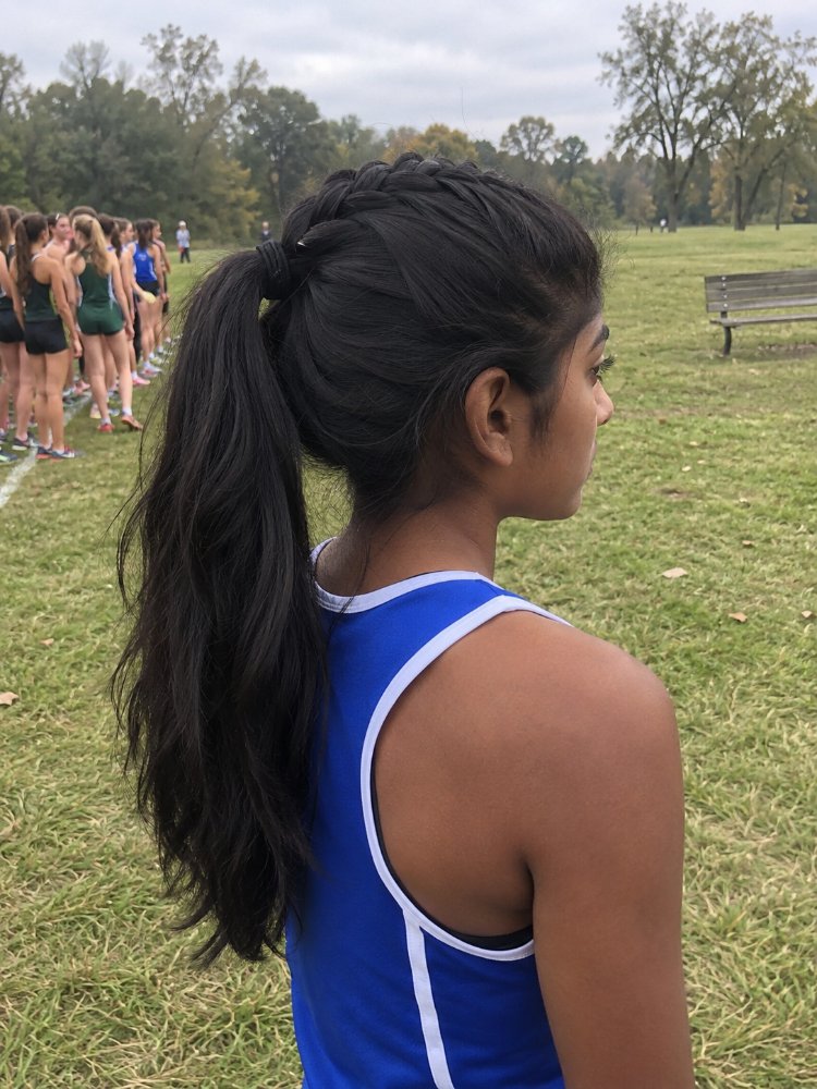 dark brown falls mid back length The hair is dark brown and falls to mid-back length. It is styled in a high ponytail with a French braid detail at the crown, and has a wavy texture. The hair appears to be a single, uniform color with dimensional color, and has a sleek, smooth finish with visible curls or braids besides the French braid detail
