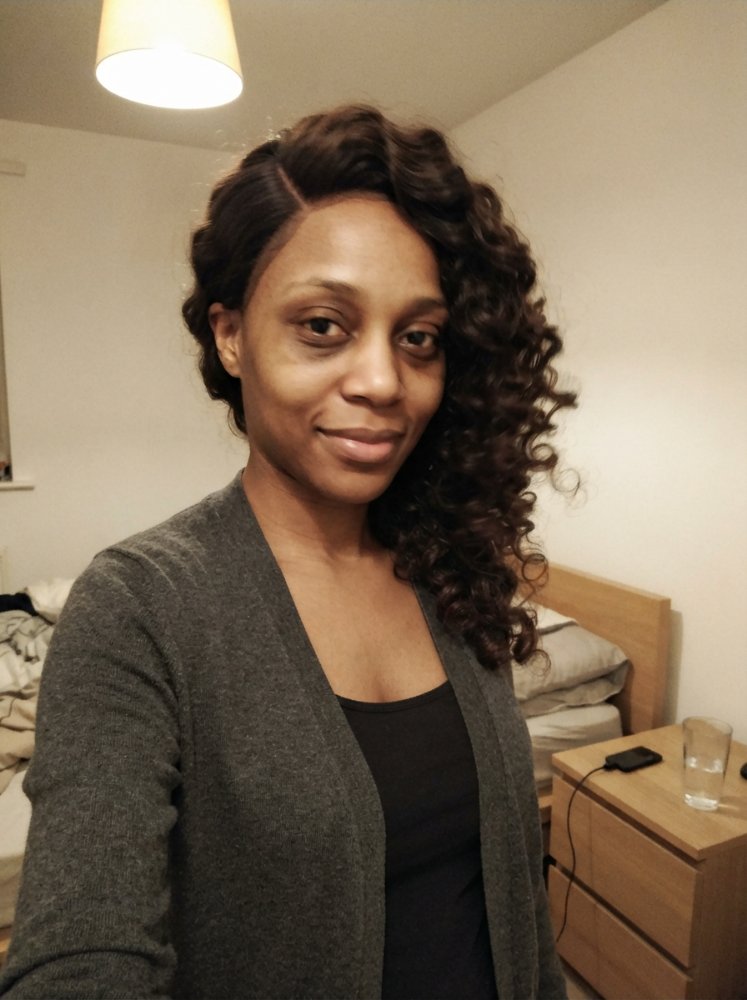 The hair is dark brown with a rich, deep color and a curly texture
