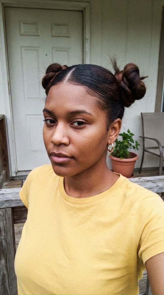 The hair is dark brown and styled in two buns on either side of the head