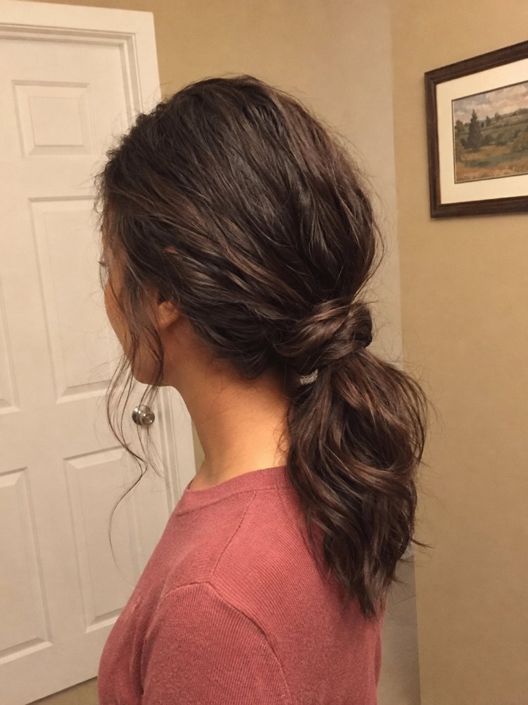 dark brown subtle highlights appearing The hair is dark brown with subtle highlights, a medium to long length, reaching down to the middle of the back