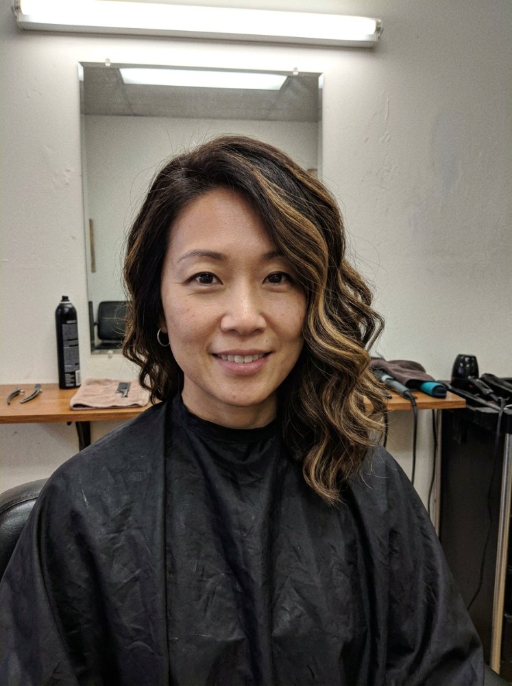 The hair is dark brown with subtle highlights of lighter brown, adding dimension and texture