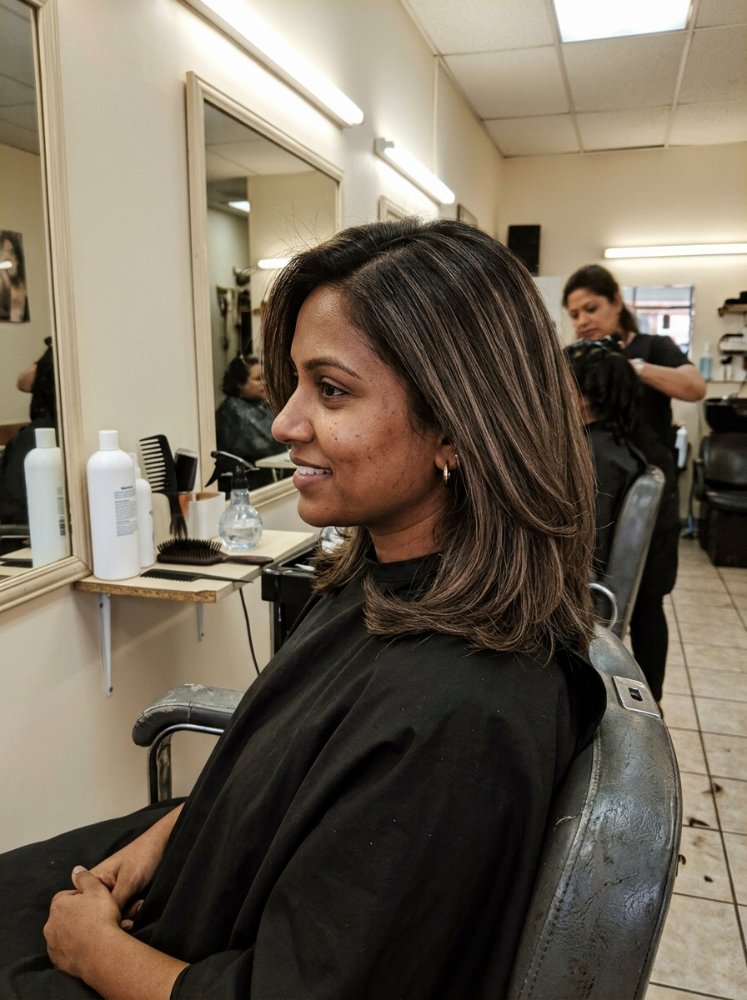 The hair is dark brown with subtle highlights of lighter brown, creating dimension and a multi-tonal effect