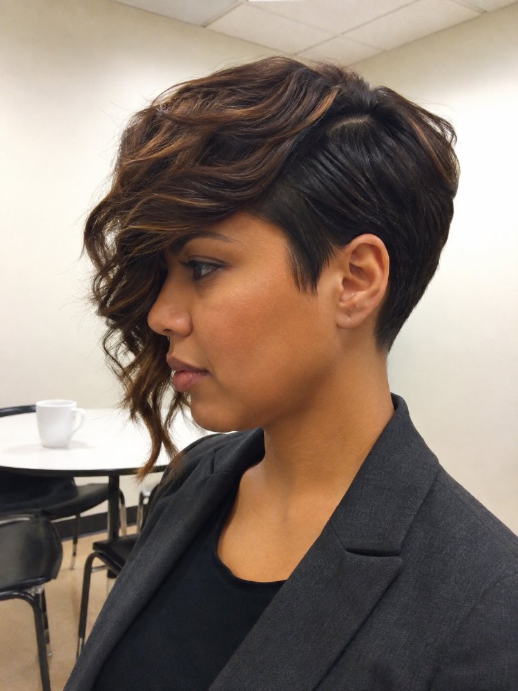 dark brown subtle highlights lighter The hair is dark brown with subtle highlights of lighter brown, and appears to be short in length, reaching just above the ears and nape of the neck. The texture is wavy and smooth, with choppy layers framing the face and adding dimension to the overall style, which features a side-swept fringe and a pixie cut