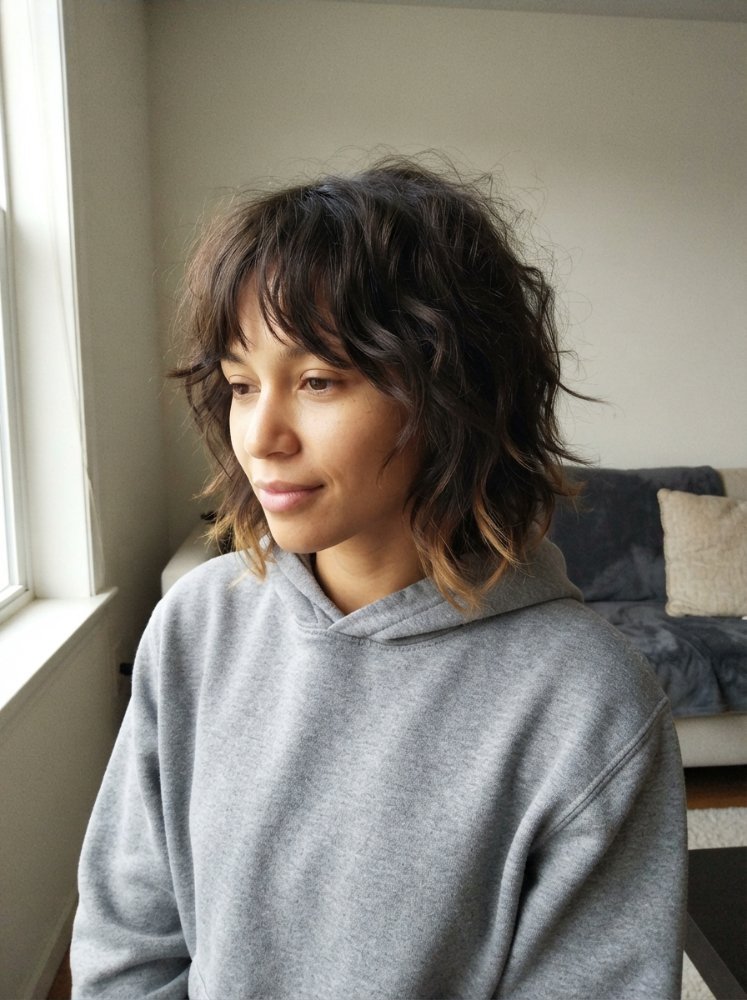 The hair is dark brown with subtle lighter brown highlights, particularly noticeable towards the ends, giving it a multi-dimensional appearance.