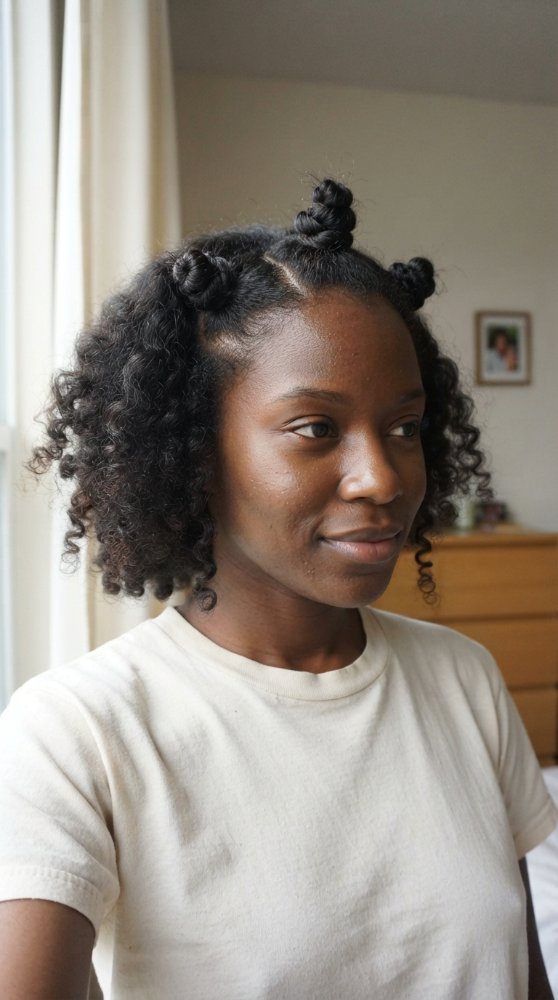 The hair is dark in color and falls just below the shoulders in length