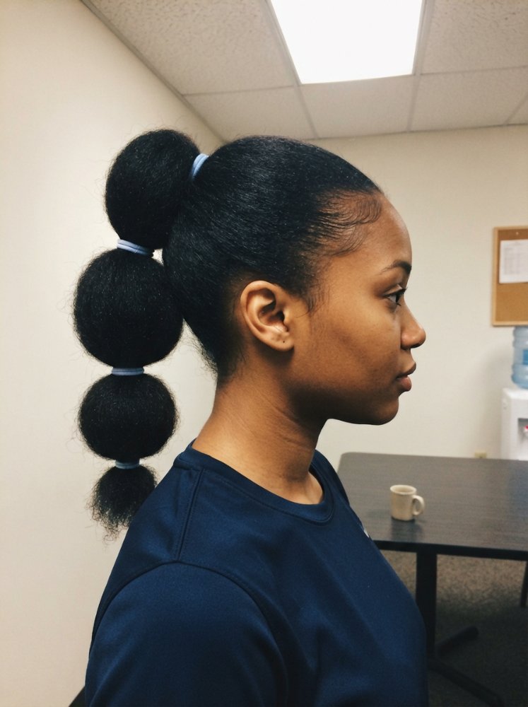 The hair is dark in color, with a smooth and sleek texture, styled into four large bubbles or buns that are stacked on top of each other, secured with light blue hair ties