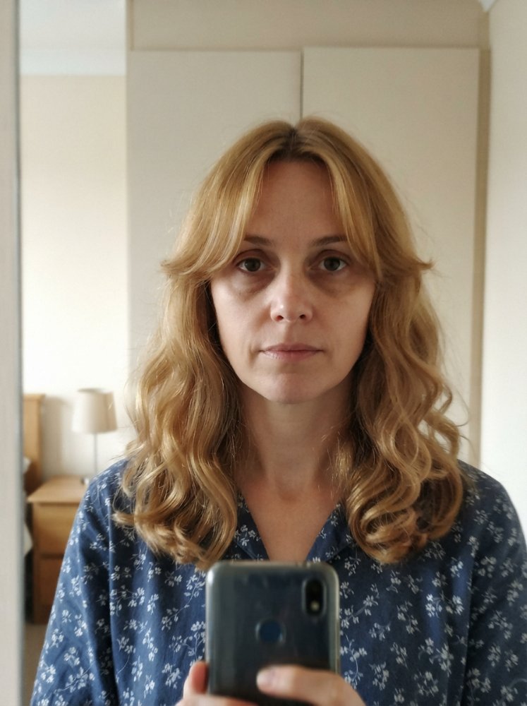 The hair is a light blonde color with subtle dimension and a slightly wavy texture