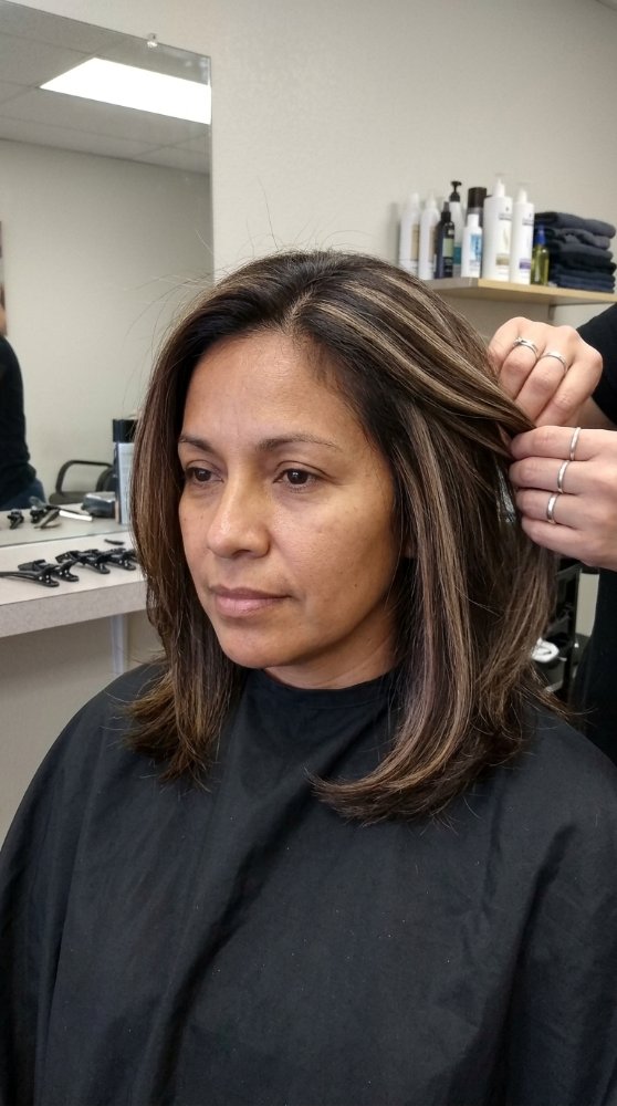 The hair is a medium to dark brown color with subtle highlights of lighter brown and blonde, adding dimension and texture