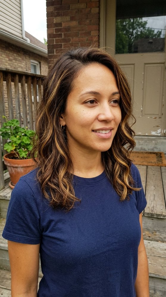 The hair is a medium to dark brown color with subtle highlights of lighter brown and blonde, adding dimension and texture