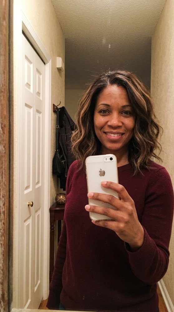 The hair is a medium to dark brown color with subtle highlights of lighter brown and blonde, adding dimension and texture