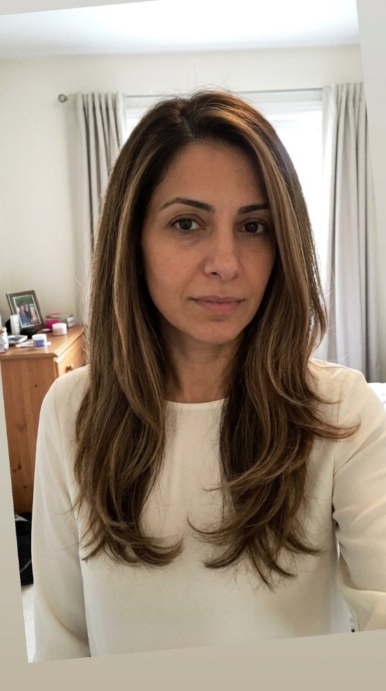 The hair is a medium to dark brown color with subtle highlights of lighter brown and blonde, giving it dimension and depth