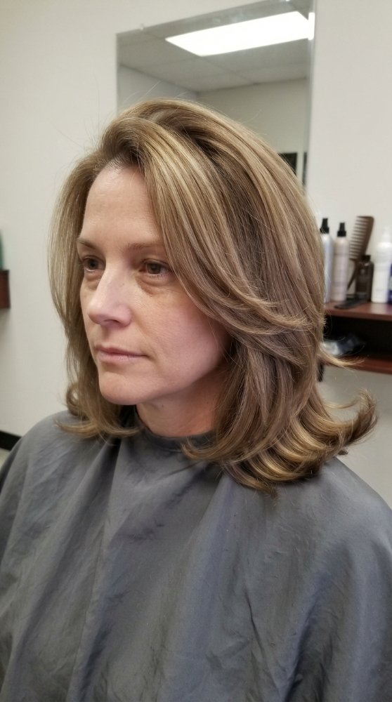 The hair is a medium-length, multi-dimensional blonde color with subtle highlights and lowlights, creating a natural-looking highlights effect