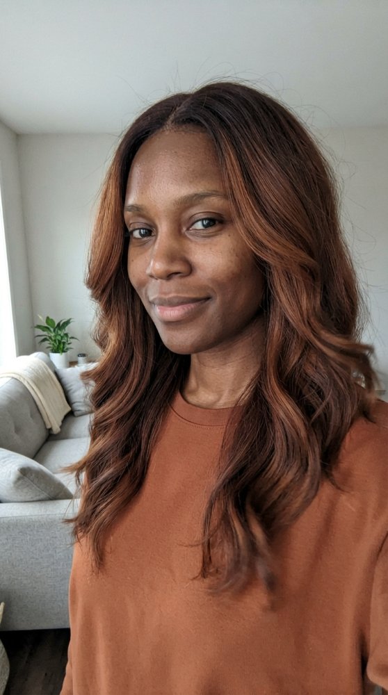 The hair is a rich, dark brown color with subtle highlights of lighter brown and copper tones, adding dimension and depth