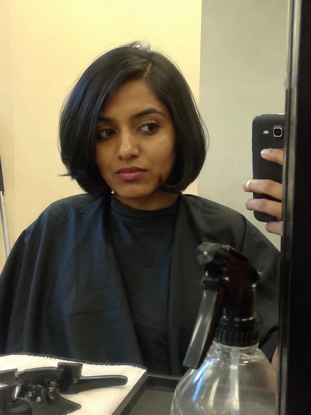 salon mirror photo of short Korean bob with side part and rounded ends