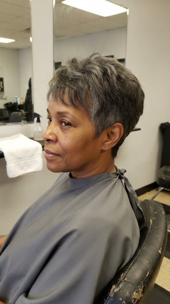 The hair is short in length, with a dark brown base color and visible gray roots