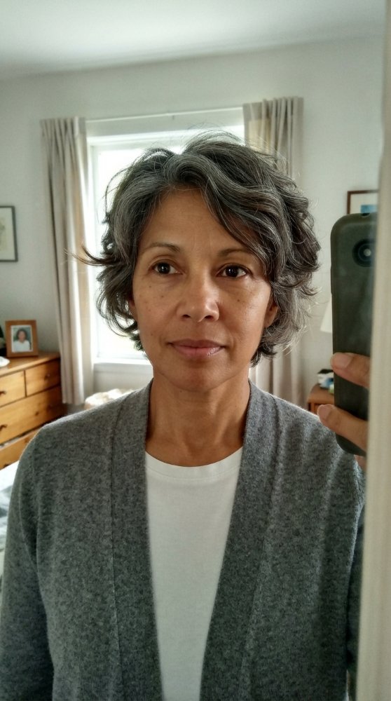 The hair is short in length, with a wavy texture and a predominantly gray color