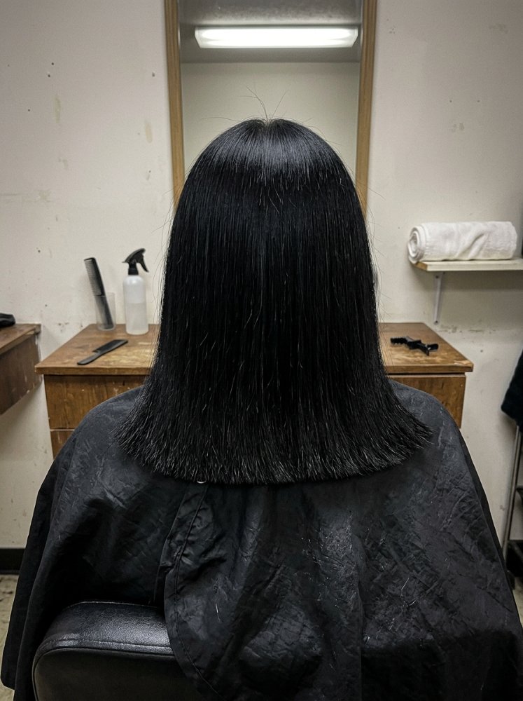 The hair is a solid black color, cut to a blunt, straight line that falls just below the shoulders