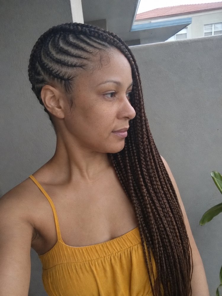 The hair is styled in long, dark brown box braids that extend down to a considerable length.