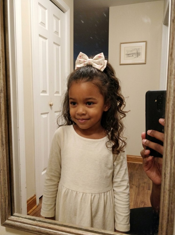 Dark brown hair with loose spiral curls falling to shoulders.