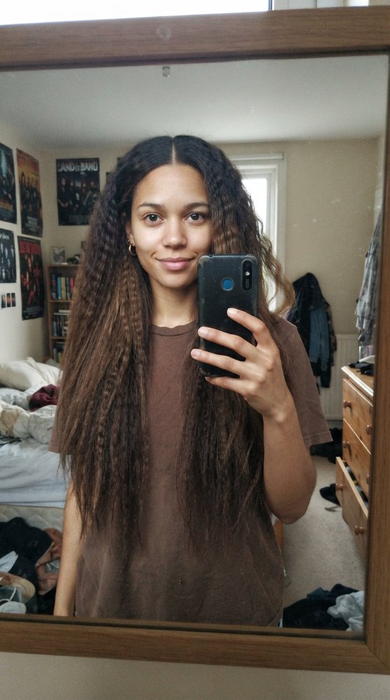 The hair visible in the is long, with a dark brown base color that transitions to lighter brown towards the ends, giving it a subtle dimension.