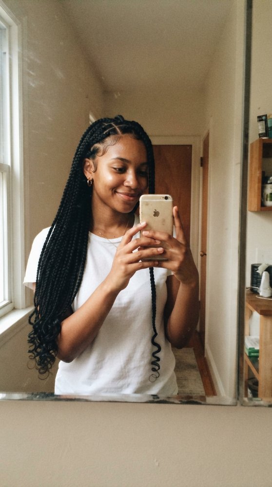 The hair visible in the is long, with a dark color, and is styled in box braids that extend down to a considerable length