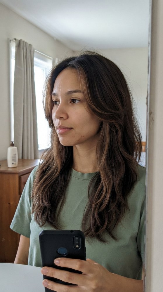 long, wavy, and dark brown in color with subtle highlights of lighter brown
